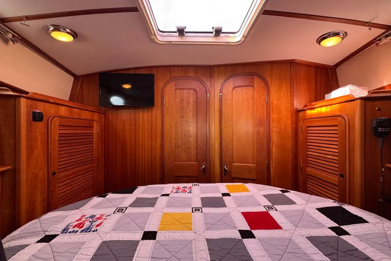 Slide: The Image of Luxurious 2001 Hinckley Talaria 44 cabin interior with wood paneling and quilted bedspread. - 33