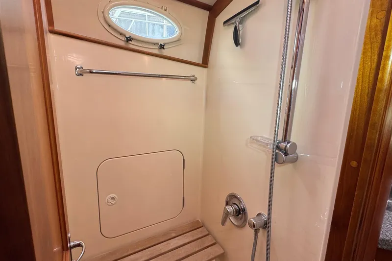 Slide: The Image of Shower area in 2001 Hinckley Talaria 44 yacht with wooden accents and porthole window. - 38