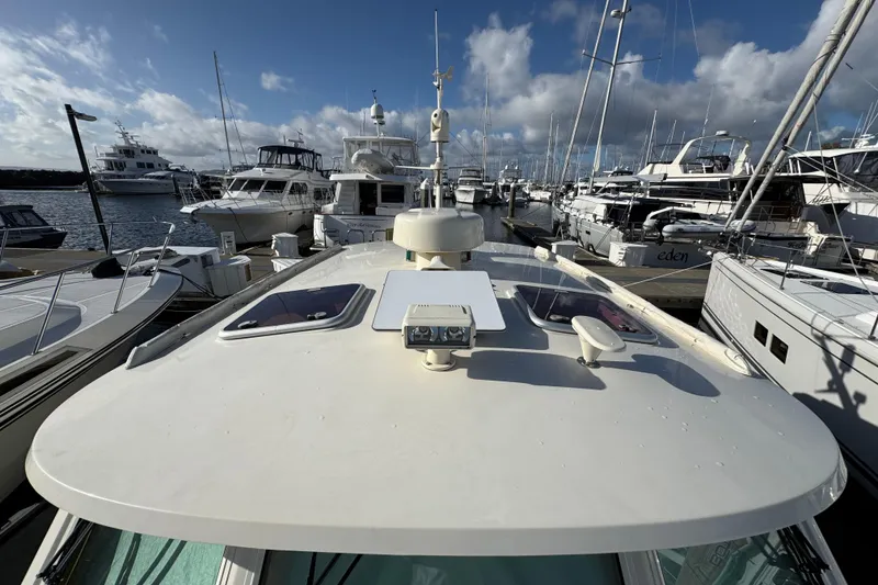 Slide: The Image of Hinckley Talaria 44 yacht docked at marina, surrounded by other boats, under a partly cloudy sky. - 44