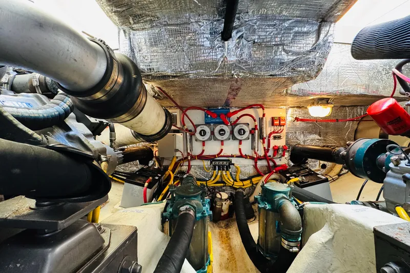 Slide: The Image of Engine room of 2001 Hinckley Talaria 44 yacht, showcasing complex machinery and wiring. - 48