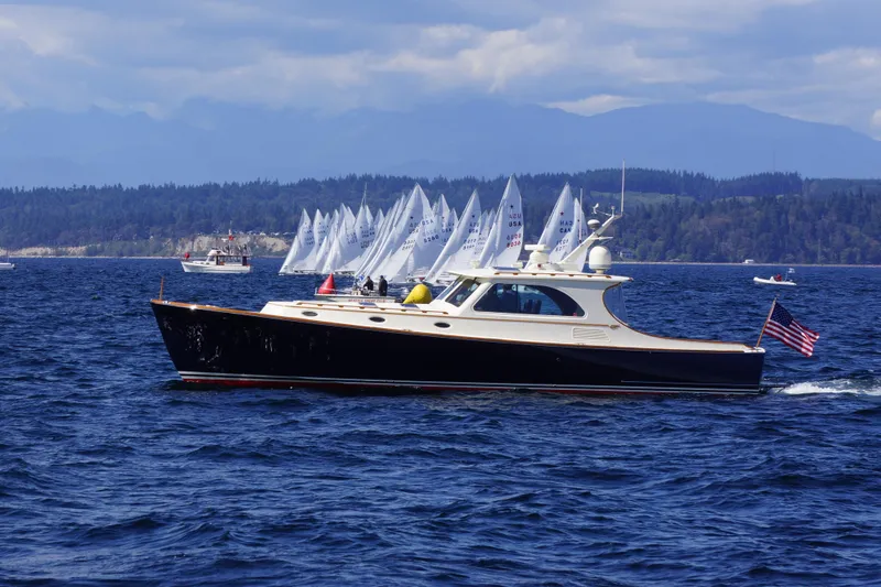Slide: The Image of Hinckley Talaria 44 yacht cruising on a scenic lake with sailboats in the background, 2001 model. - 57