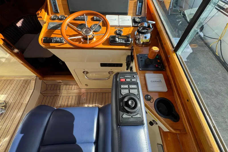 Slide: The Image of 2001 Hinckley Talaria 44 helm with wooden steering wheel and modern navigation controls. - 6