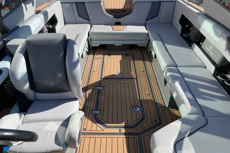 Slide: The Image of 2020 Nautique Super Air Nautique G25 interior with luxurious seating and teak-style flooring. - 12