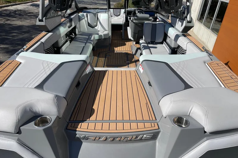 Slide: The Image of 2020 Nautique Super Air Nautique G25 interior with luxurious seating and teak flooring. - 4