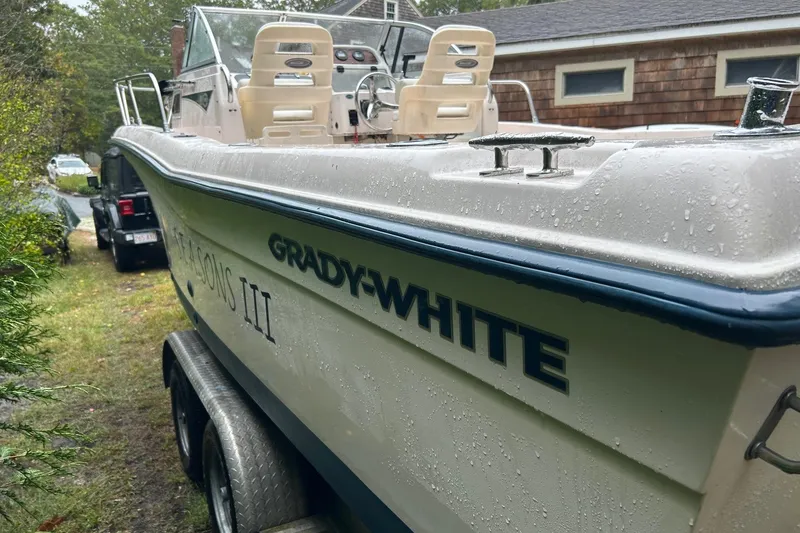 The Image of 1998 Grady-White Seafarer 226 boat on trailer, wet from rain, parked outdoors. - 0