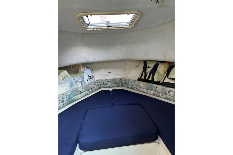 Slide: The Image of 1998 Grady-White Seafarer 226 cabin interior with blue cushions and storage space. - 14