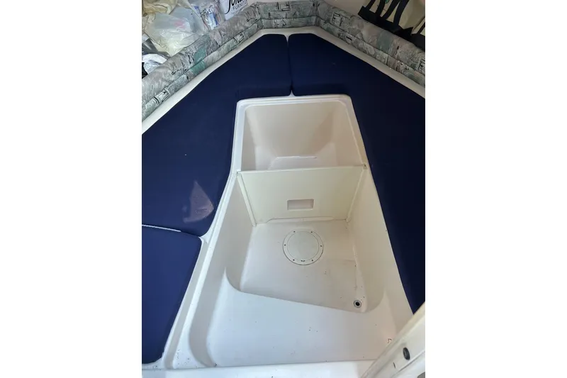Slide: The Image of 1998 Grady-White Seafarer 226 cabin interior with blue cushions and storage compartment. - 15