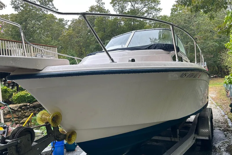 Slide: The Image of 1998 Grady-White Seafarer 226 boat on trailer, surrounded by greenery. - 2