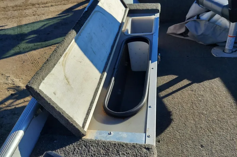 Slide: The Image of 1997 Alumacraft Backtroller 14 boat interior storage compartment with open lid. - 8