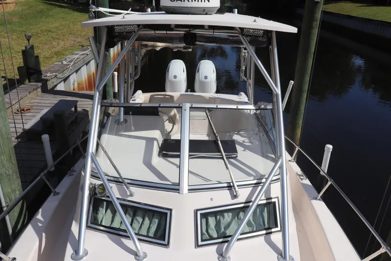 Slide: The Image of 1999 Grady-White Islander 268 boat docked, featuring dual engines and sturdy metal framework. - 20