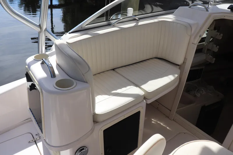 Slide: The Image of 1999 Grady-White Islander 268 boat interior with white cushioned seating. - 28