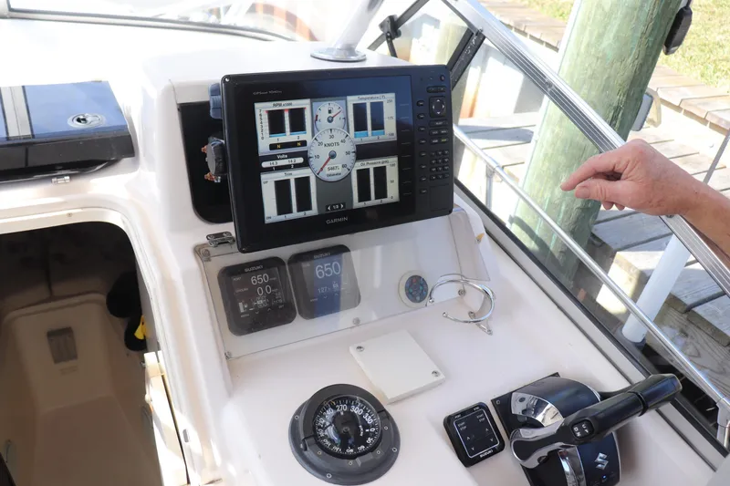 Slide: The Image of 1999 Grady-White Islander 268 boat dashboard with Garmin navigation system and controls. - 34