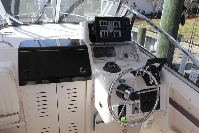 Slide: The Image of 1999 Grady-White Islander 268 boat helm with steering wheel and navigation equipment. - 35