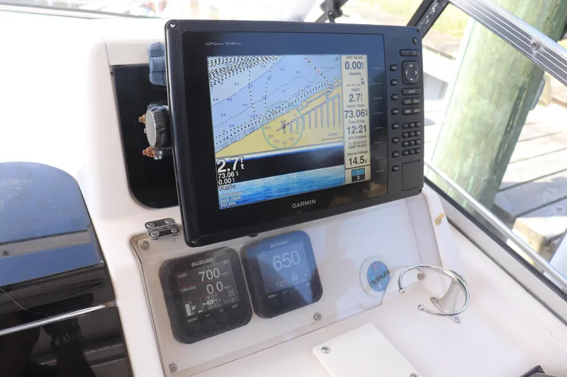 Slide: The Image of 1999 Grady-White Islander 268 boat dashboard with Garmin GPS and Suzuki engine displays. - 37