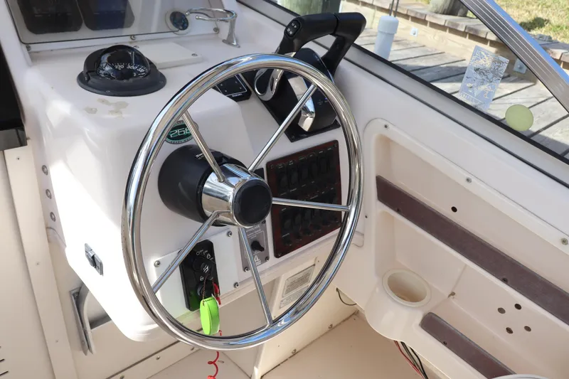Slide: The Image of 1999 Grady-White Islander 268 boat steering wheel and control panel. - 38
