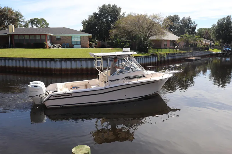Slide: The Image of 1999 Grady-White Islander 268 boat cruising on a calm residential canal. - 44