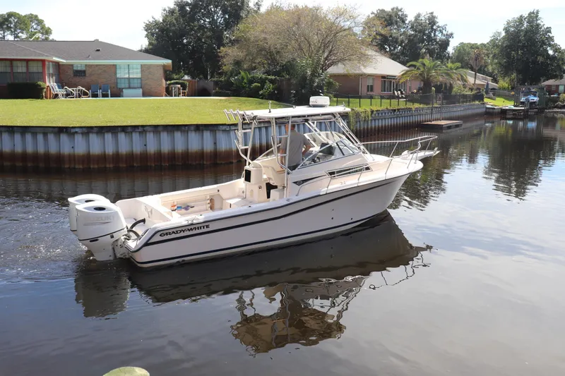 Slide: The Image of 1999 Grady-White Islander 268 boat cruising on a calm residential canal. - 45