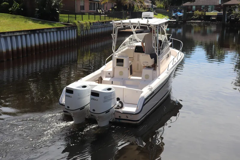Slide: The Image of 1999 Grady-White Islander 268 boat with dual Suzuki engines on a calm waterway. - 46