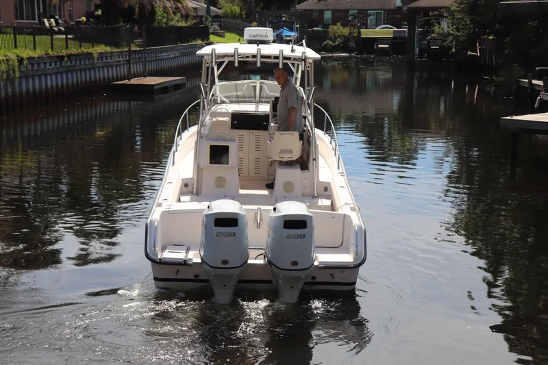 Slide: The Image of 1999 Grady-White Islander 268 boat navigating a calm canal with dual engines. - 47