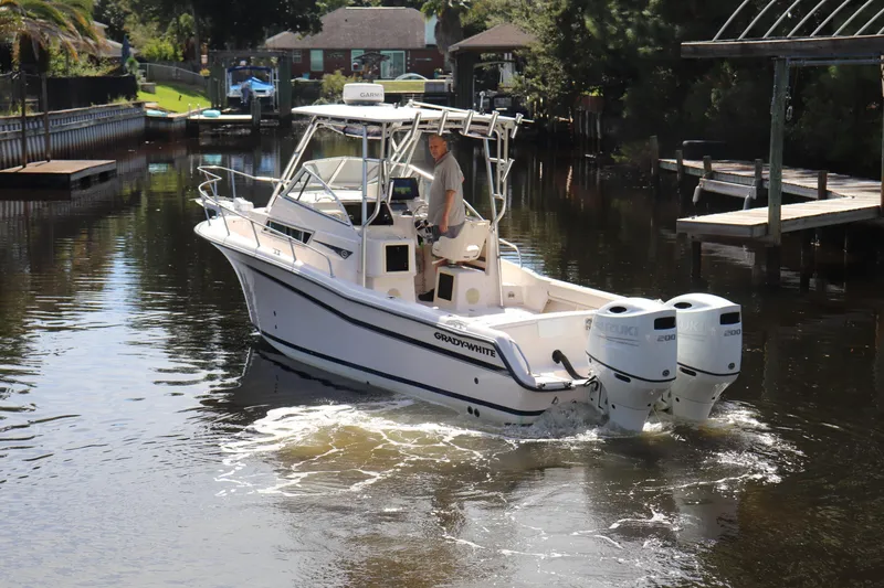 Slide: The Image of 1999 Grady-White Islander 268 boat navigating a calm waterway with twin Suzuki engines. - 48
