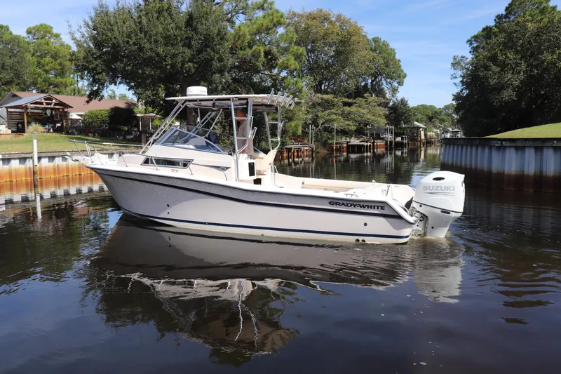 Slide: The Image of 1999 Grady-White Islander 268 boat on a calm river, surrounded by trees. - 53