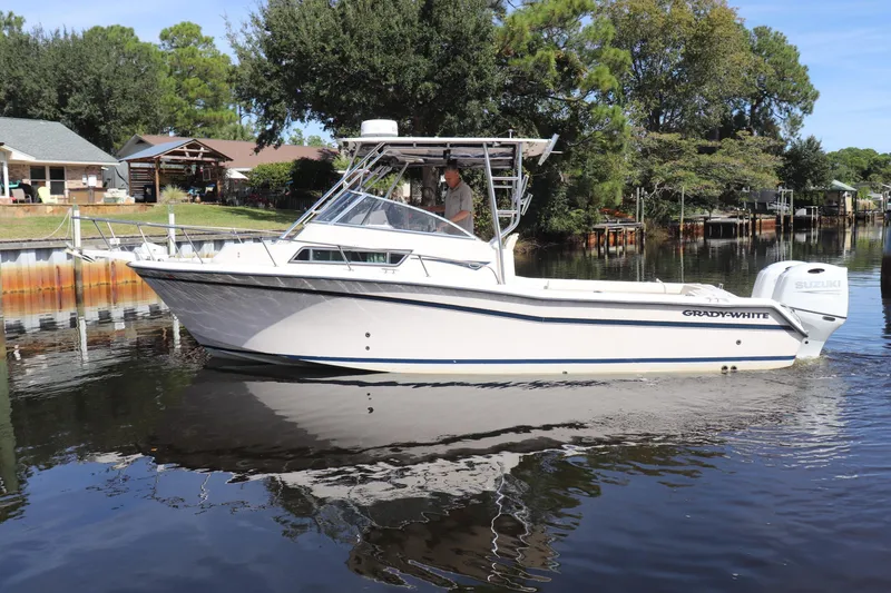 Slide: The Image of 1999 Grady-White Islander 268 boat cruising on a calm river. - 55