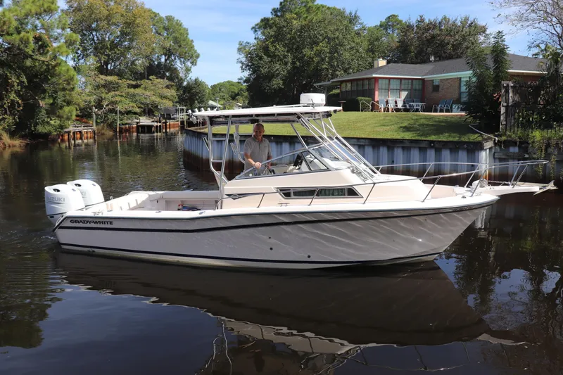 Slide: The Image of 1999 Grady-White Islander 268 boat cruising on a calm river near a house. - 60