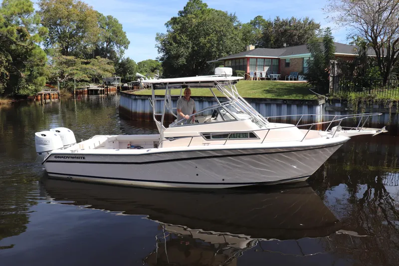 Slide: The Image of 1999 Grady-White Islander 268 boat on a calm river near a house. - 61