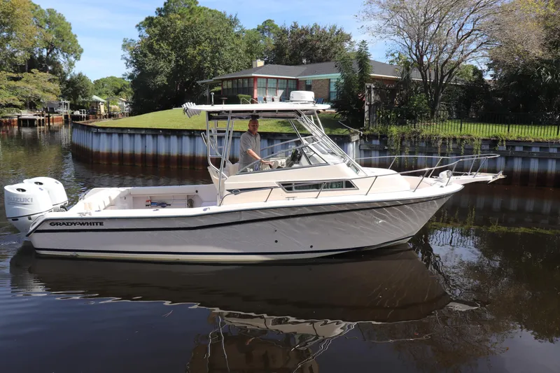 Slide: The Image of 1999 Grady-White Islander 268 boat on calm water near a residential area. - 62
