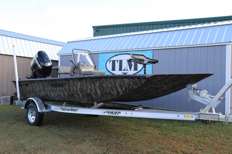 Slide: The Image of 2026 SeaArk Shadow 18T CC boat on trailer, camo design, parked outdoors. - 8
