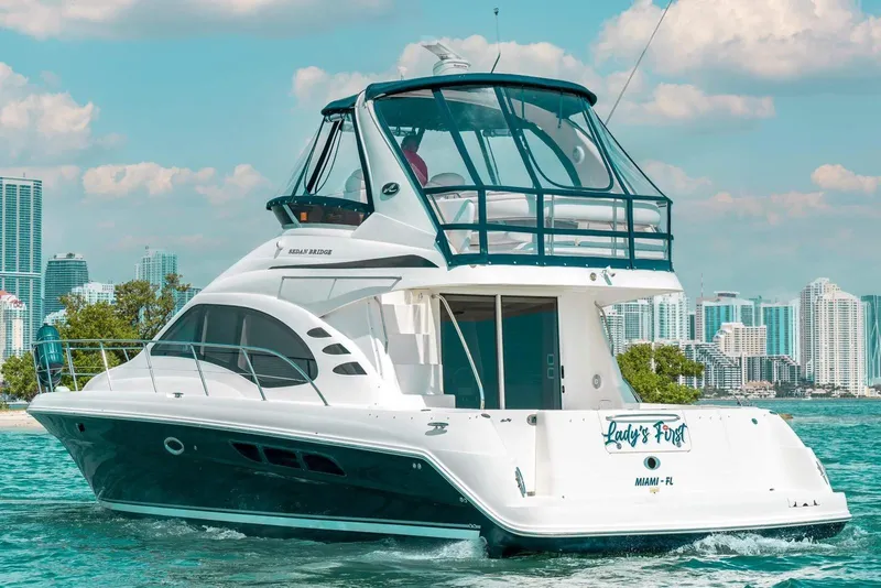 Slide: The Image of 2005 Sea Ray 420 Sedan Bridge yacht cruising near Miami skyline. - 10