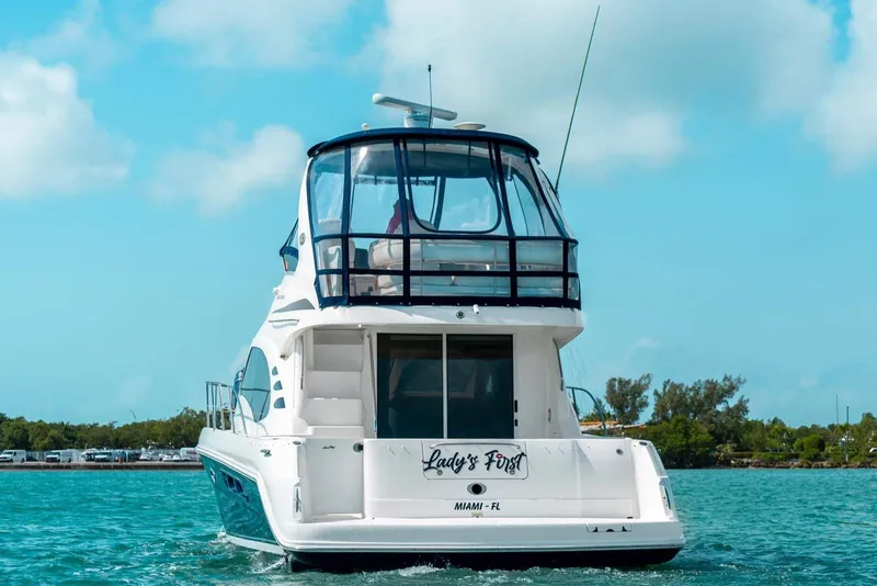 Slide: The Image of 2005 Sea Ray 420 Sedan Bridge yacht on clear blue water, rear view. - 11