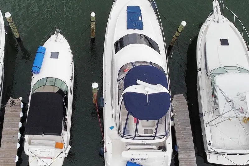Slide: The Image of Aerial view of a 2005 Sea Ray 420 Sedan Bridge yacht docked between two boats. - 16