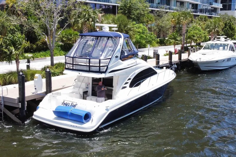 Slide: The Image of 2005 Sea Ray 420 Sedan Bridge yacht docked by lush greenery and waterfront. - 19