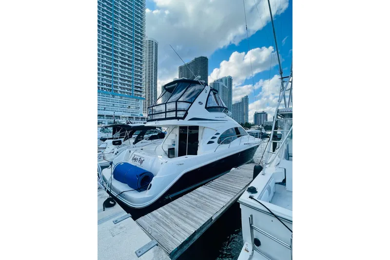 Slide: The Image of 2005 Sea Ray 420 Sedan Bridge yacht docked in a marina with city skyline. - 21