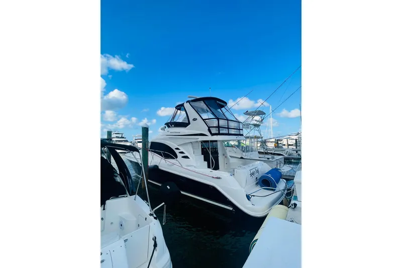 Slide: The Image of 2005 Sea Ray 420 Sedan Bridge yacht docked under a clear blue sky. - 22