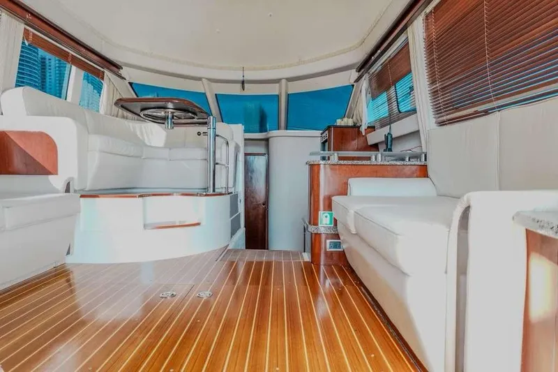 Slide: The Image of Interior of 2005 Sea Ray 420 Sedan Bridge with wood flooring and white seating. - 28
