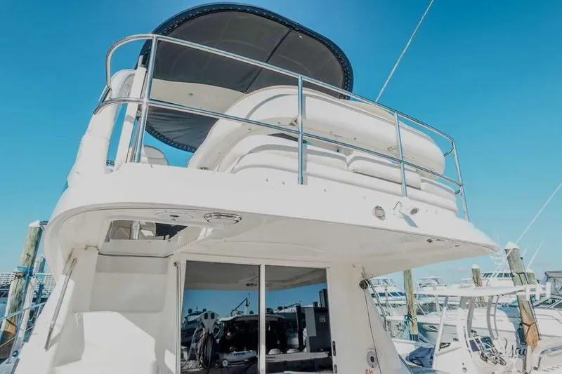 Slide: The Image of 2005 Sea Ray 420 Sedan Bridge yacht docked under clear blue sky. - 31