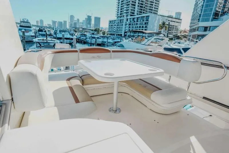Slide: The Image of 2005 Sea Ray 420 Sedan Bridge yacht interior with seating and table, docked in marina. - 35