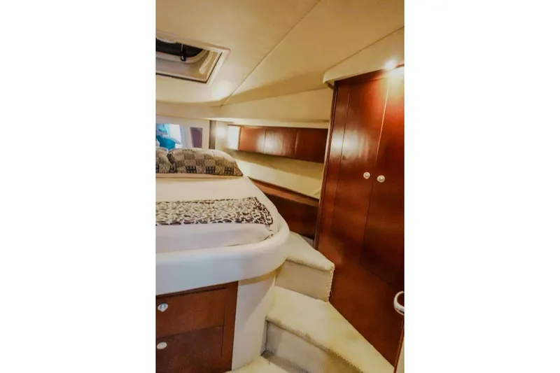 Slide: The Image of 2005 Sea Ray 420 Sedan Bridge cabin interior with bed and wooden cabinetry. - 47