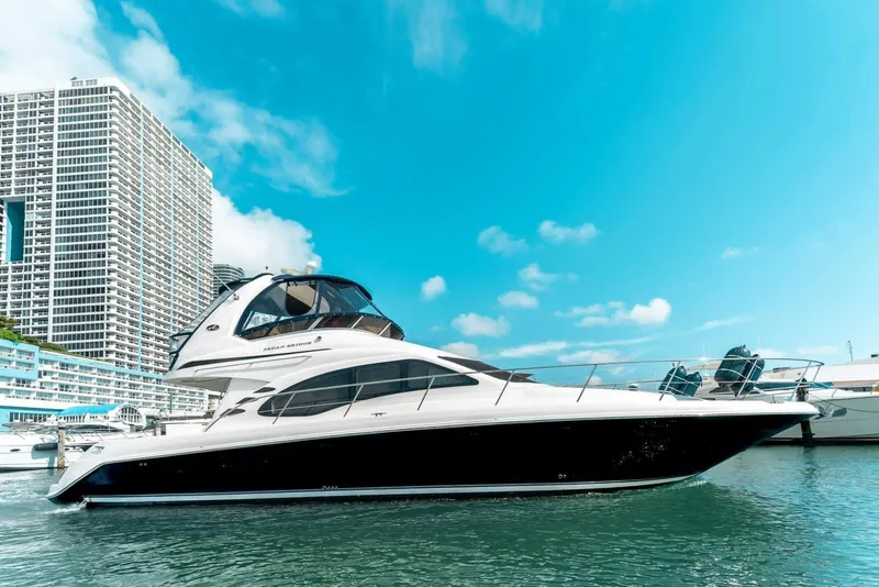 Slide: The Image of 2005 Sea Ray 420 Sedan Bridge yacht docked near modern high-rise buildings. - 6
