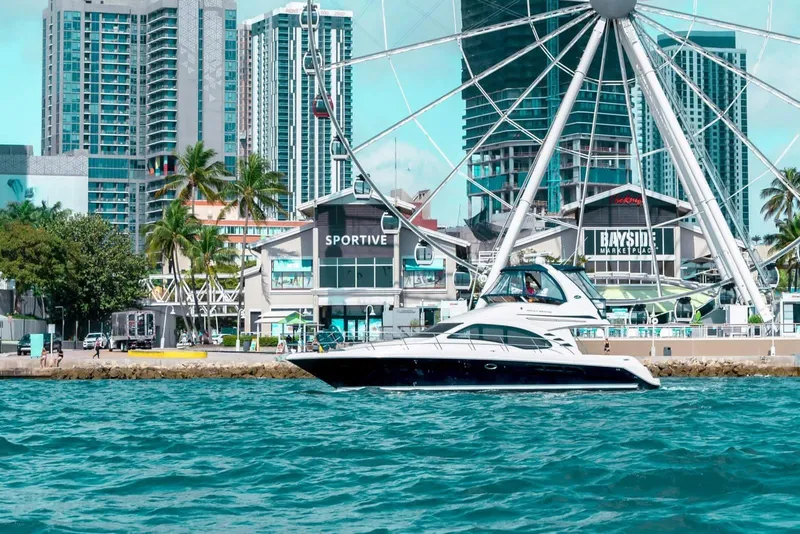 Slide: The Image of 2005 Sea Ray 420 Sedan Bridge yacht cruising near urban waterfront with Ferris wheel. - 9