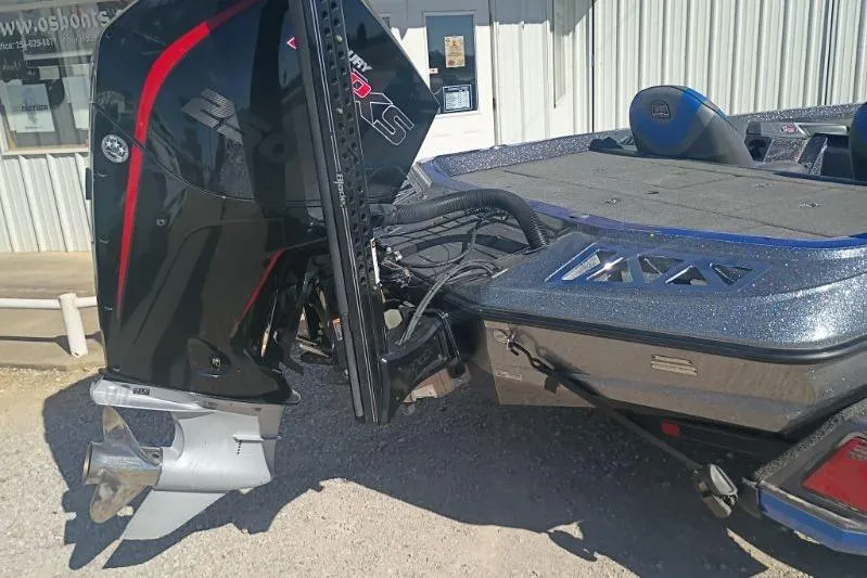 Slide: The Image of 2021 Ranger Z521L boat with powerful outboard motor, parked outside a building. - 10