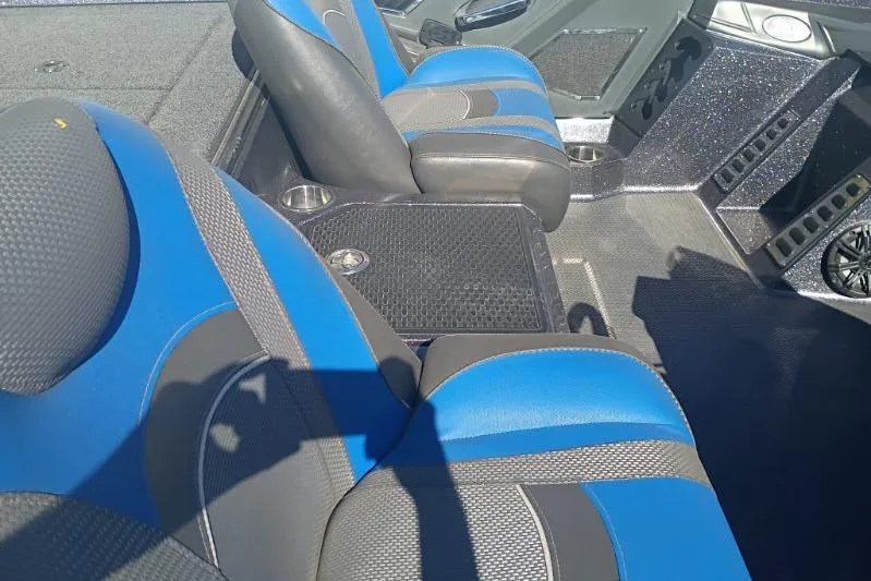 Slide: The Image of 2021 Ranger Z521L boat interior with blue and gray seats, cup holders, and storage compartments. - 9