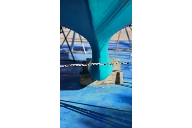 Slide: The Image of Pacific Seacraft 37 sailboat keel, 1993 model, on a blue-painted dry dock. - 17