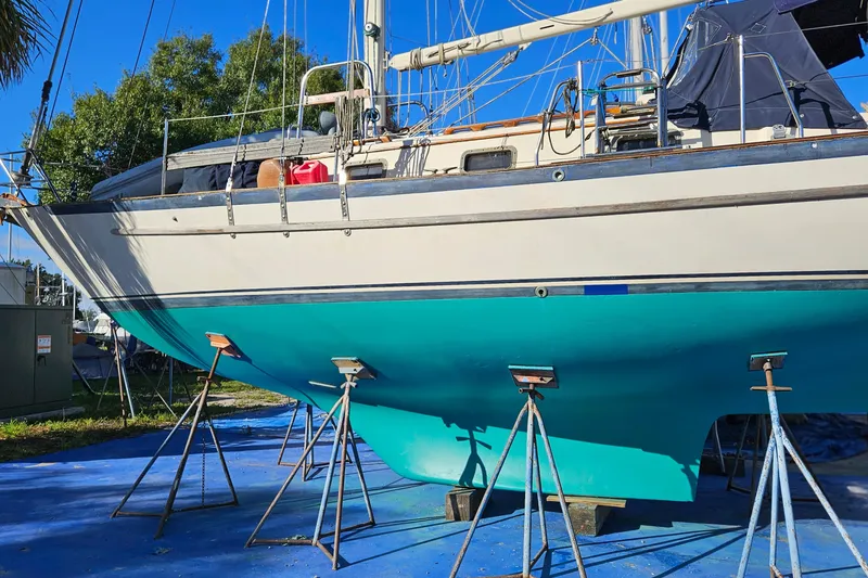 Slide: The Image of 1993 Pacific Seacraft 37 sailboat on stands, turquoise hull, outdoor setting. - 3