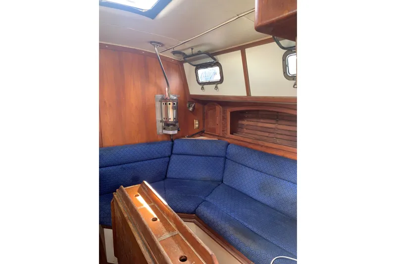 Slide: The Image of Cozy interior of 1993 Pacific Seacraft 37 sailboat with blue seating and wooden accents. - 9