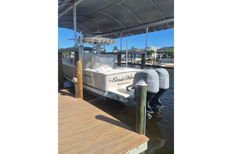 Slide: The Image of 2018 Regulator 28 boat with twin Yamaha 300 engines docked under a canopy. - 1