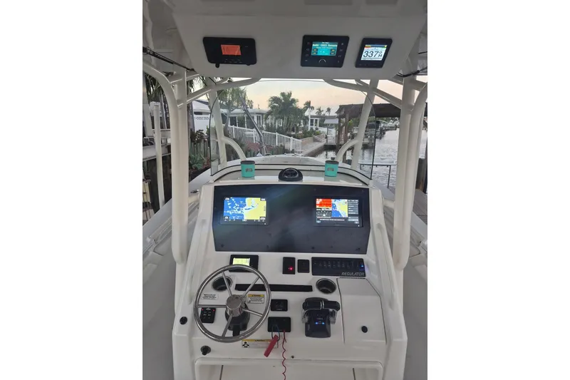 Slide: The Image of 2018 Regulator 28 boat with Minn Kota Ulterra motor docked in a scenic marina. - 3
