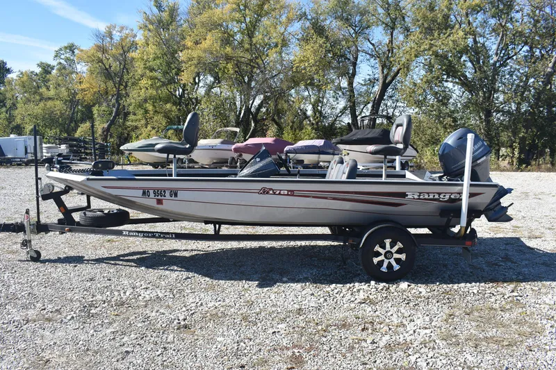 Slide: The Image of 2015 Ranger RT178C fishing boat on trailer, parked outdoors with trees in background. - 7